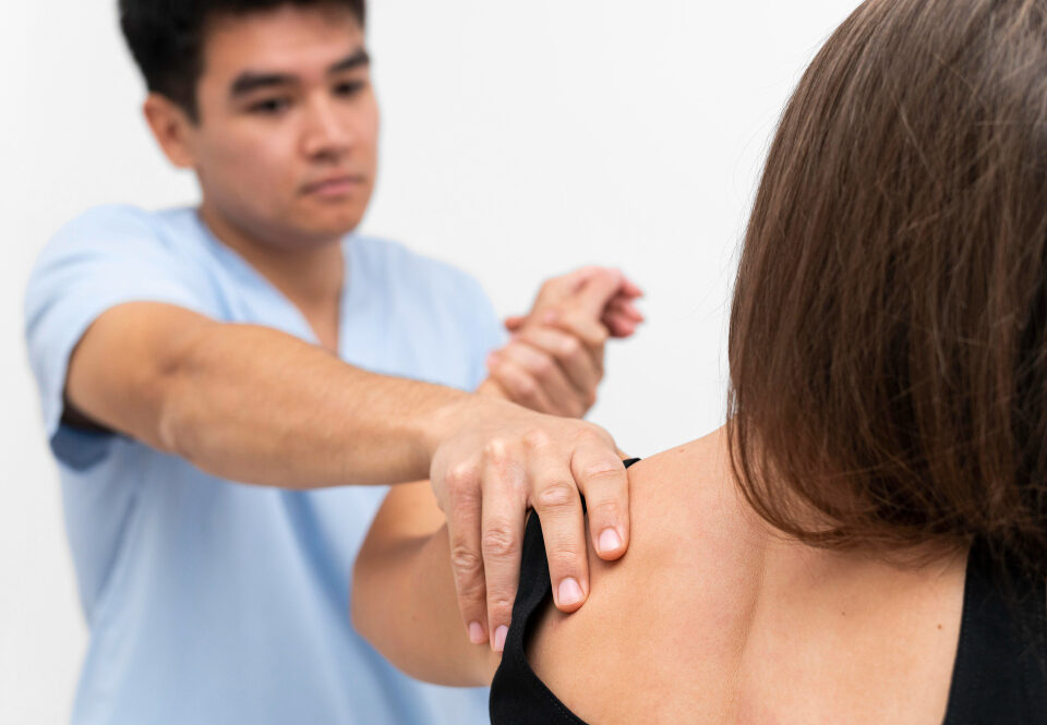 Fisioterapeuta atendendo paciente em fisioterapia após cirurgia de joelho ou ombro